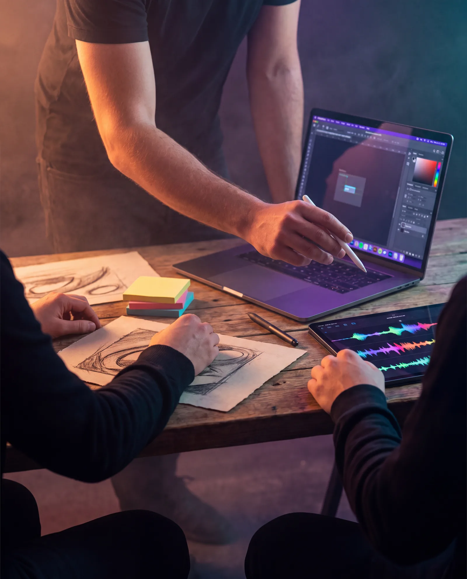 A creative team sketching and editing audio together around a studio table