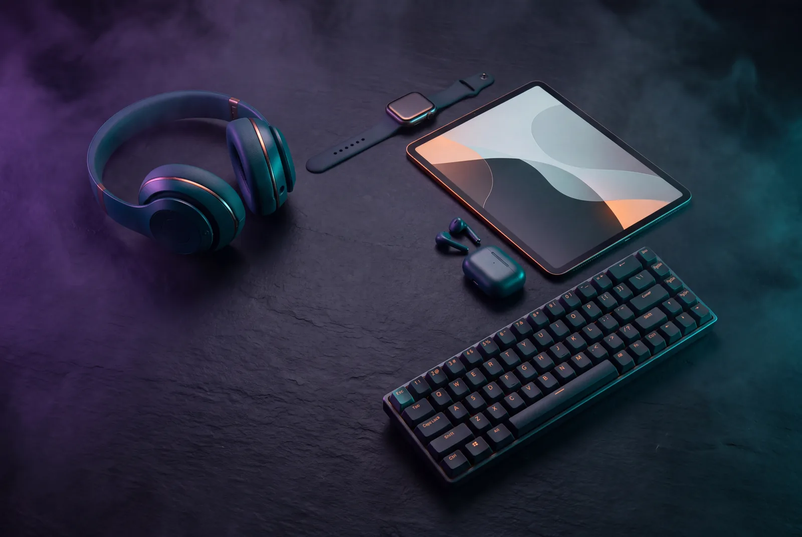 Tech flat lay with headphones, smartwatch, tablet, earbuds and a mechanical keyboard